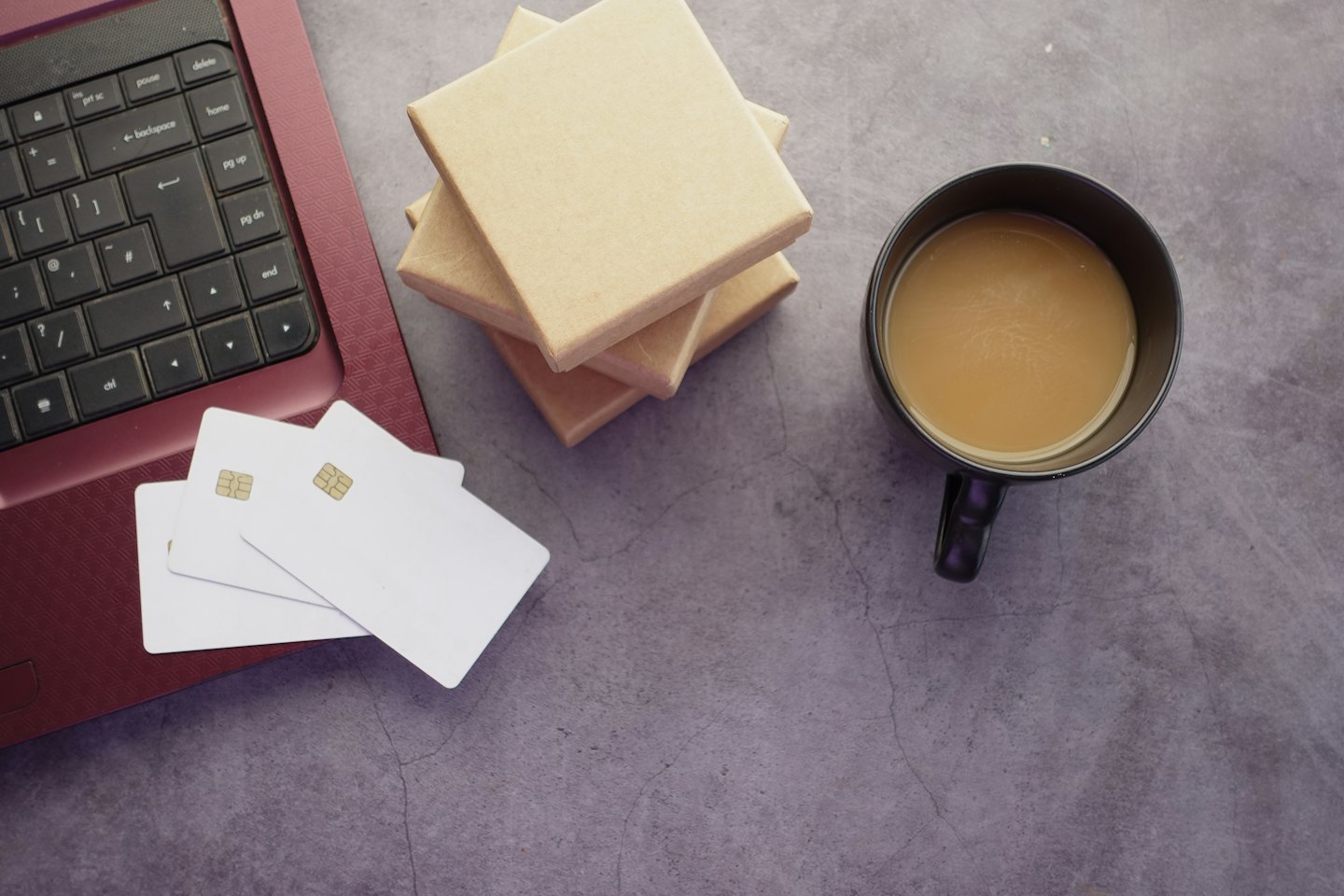 Laptop with credit cards, boxes, and coffee for online shopping.